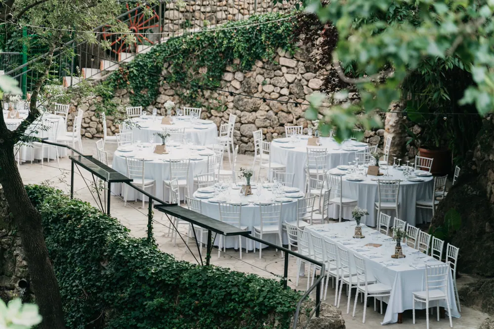 Mesas preparadas para una boda en un patio de piedra