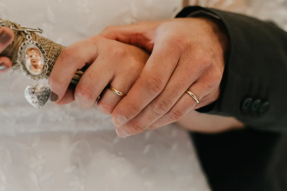 Manos de los novios mostrando sus alianzas
