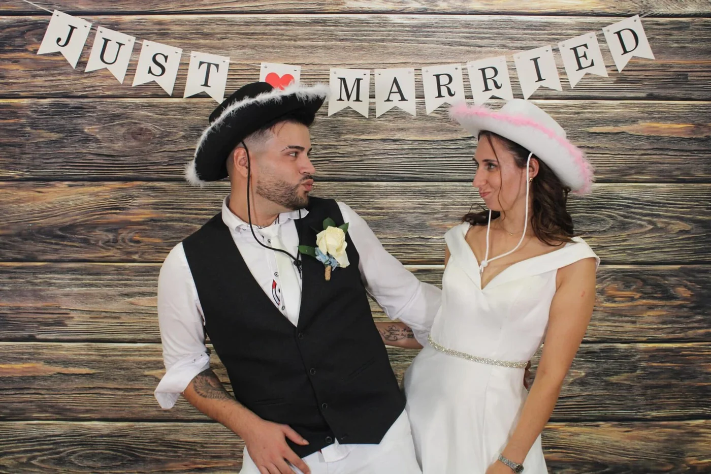 Novios con sombreros y atrezo en el fotomatón
