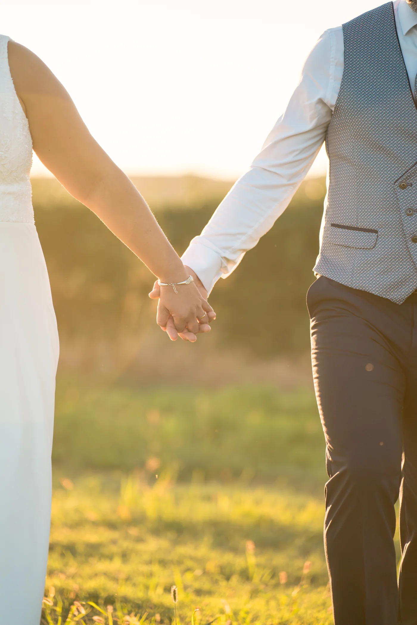 Las manos de los novios enlazadas a la luz del atardecer